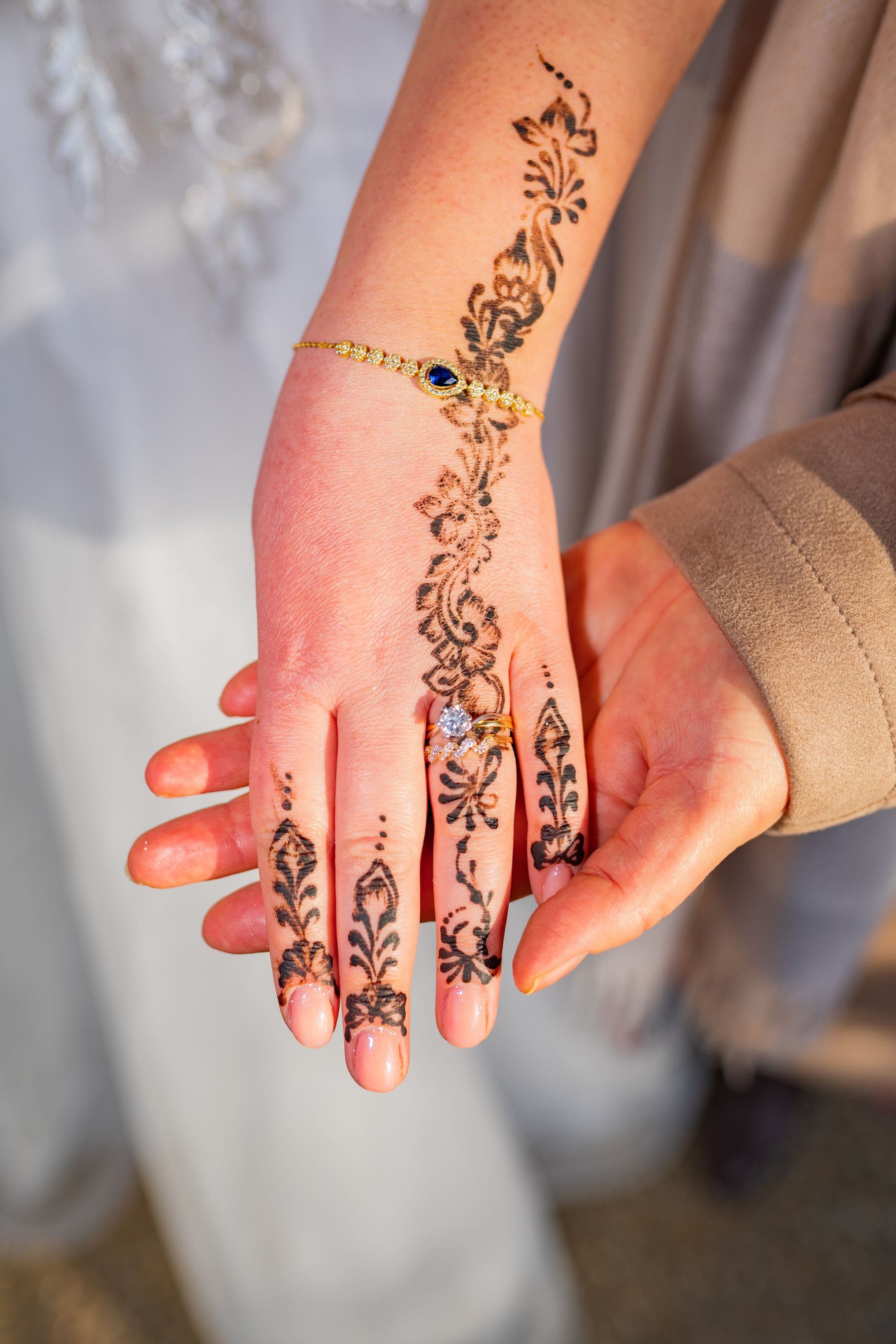 Hands with ornate henna, intertwined