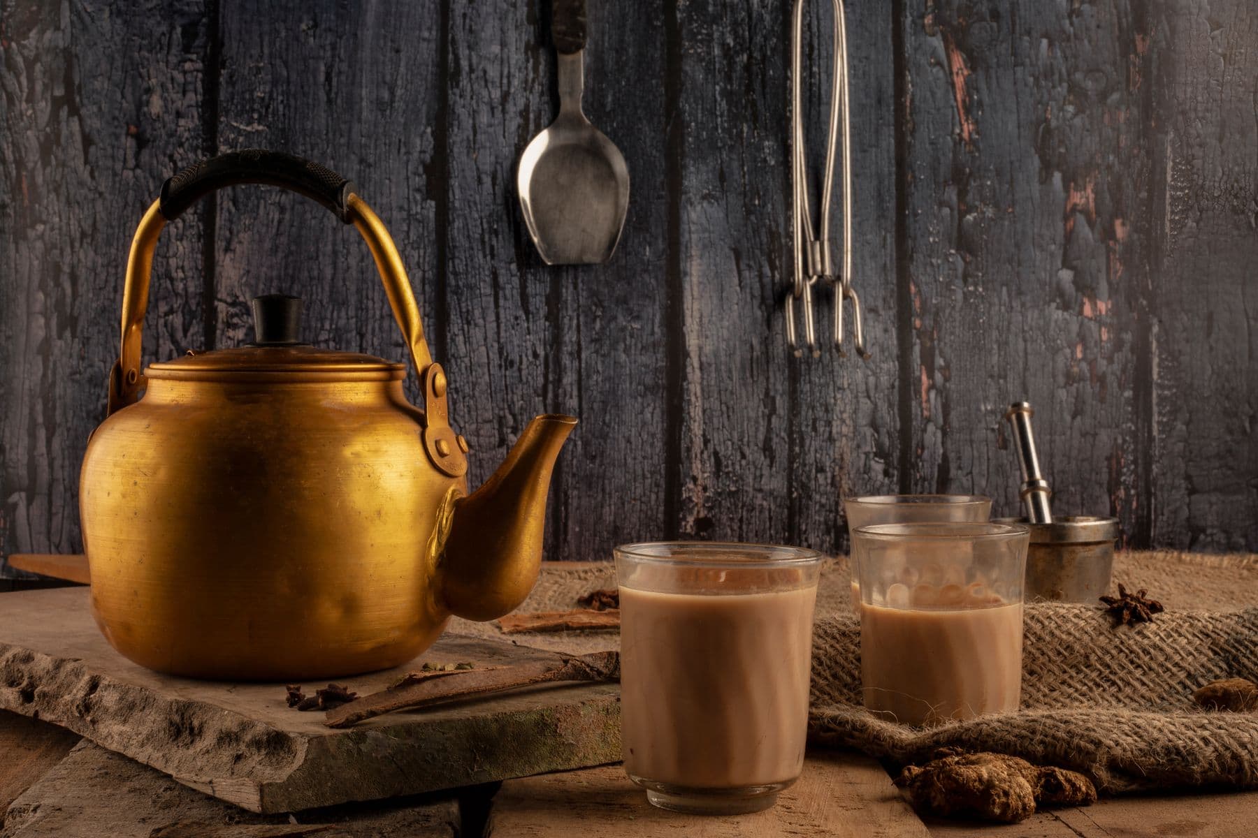 A brass kettle and chai glasses